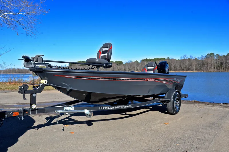 Slide: The Image of 2021 Ranger VS1660 T boat on trailer by a lake under clear blue sky. - 10