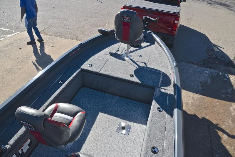 Slide: The Image of 2021 Ranger VS1660 T boat interior with seating, parked near a red truck. - 21