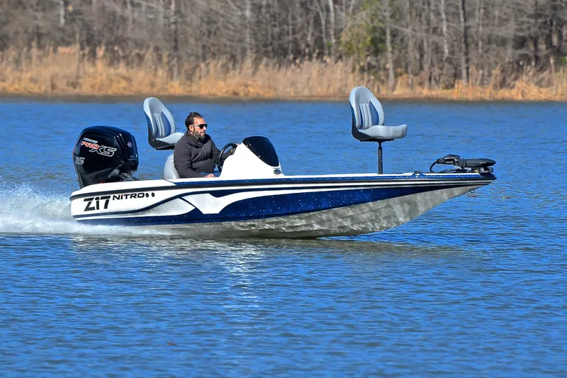 The Image of Man driving 2018 Nitro Z17 boat on a lake, surrounded by trees. - 1
