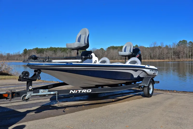 Slide: The Image of 2018 Nitro Z17 boat on trailer by a serene lake under clear blue sky. - 10