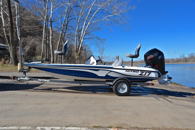 Slide: The Image of 2018 Nitro Z17 boat on trailer by a lake, under clear blue sky. - 11