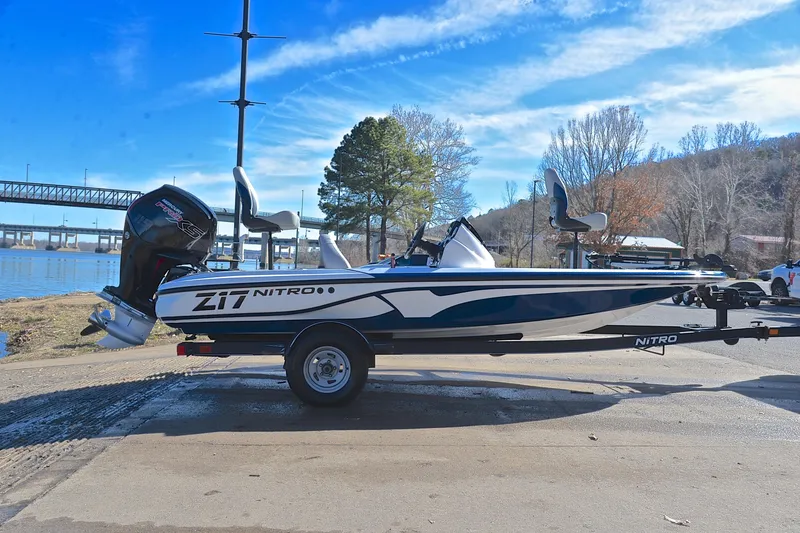 Slide: The Image of 2018 Nitro Z17 boat on trailer by a lakeside, under a clear blue sky. - 15