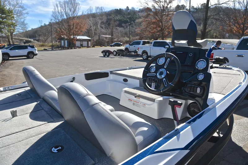 Slide: The Image of 2018 Nitro Z17 boat interior with steering wheel and seating in a parking lot. - 19