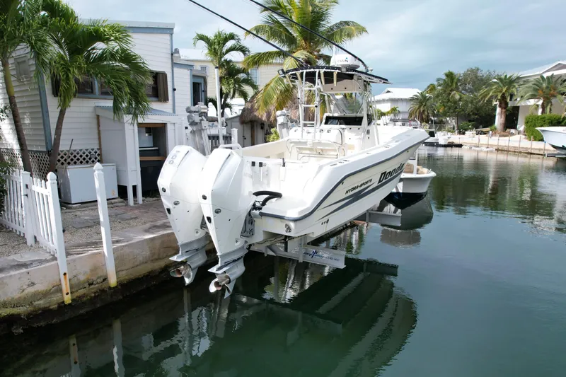 Slide: The Image of 2003 Hydra-Sports Vector 2800 CC boat docked by a waterfront home with palm trees. - 3
