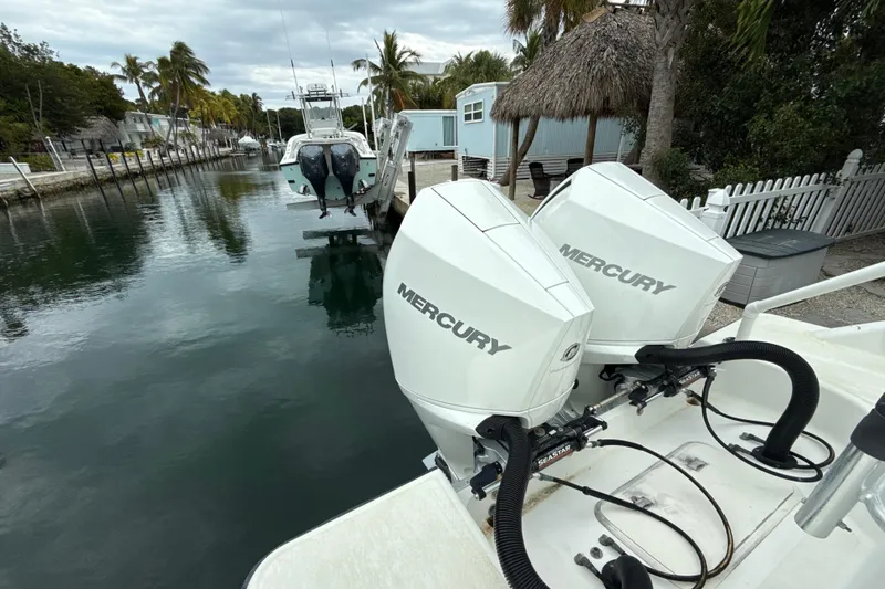 Slide: The Image of 2003 Hydra-Sports Vector 2800 CC with dual Mercury outboard engines docked by palm trees. - 5