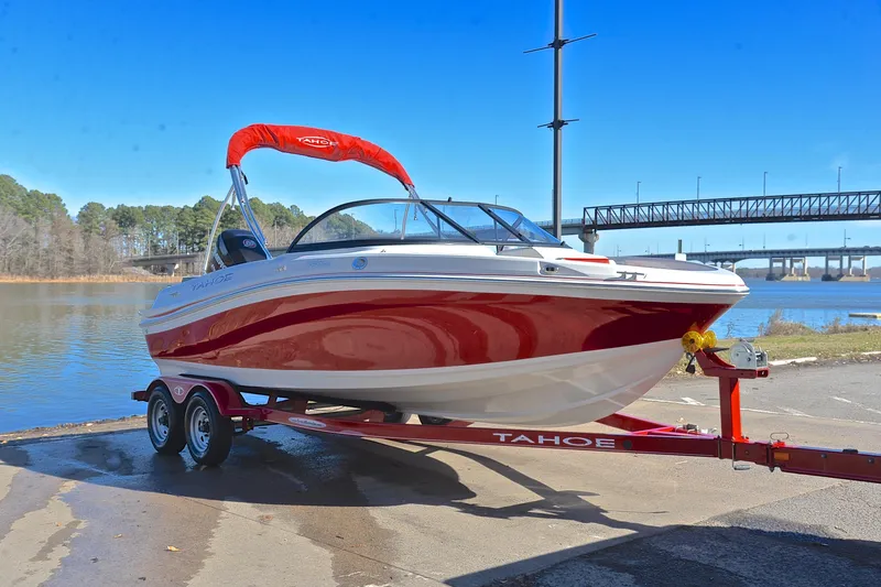 Slide: The Image of 2016 Tahoe 550 TS boat on trailer by a lake with bridge in background. - 16