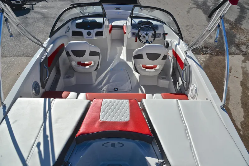 Slide: The Image of 2016 Tahoe 550 TS boat interior with red and white seating, steering wheel, and dashboard. - 18