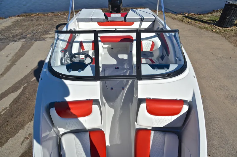 Slide: The Image of 2016 Tahoe 550 TS boat with red and white interior, docked by the water. - 20