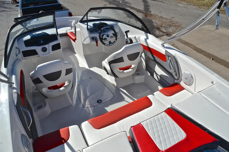 Slide: The Image of 2016 Tahoe 550 TS boat interior with red and white seating, steering wheel, and dashboard. - 23