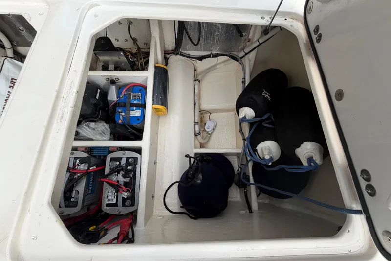 Slide: The Image of Storage compartment of a 2000 Spectre 30 Cat boat with batteries and fenders. - 14