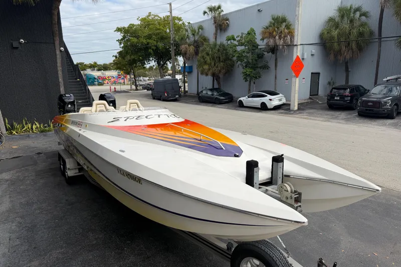 Slide: The Image of 2000 Spectre 30 Cat powerboat with vibrant orange and purple design on a trailer. - 3