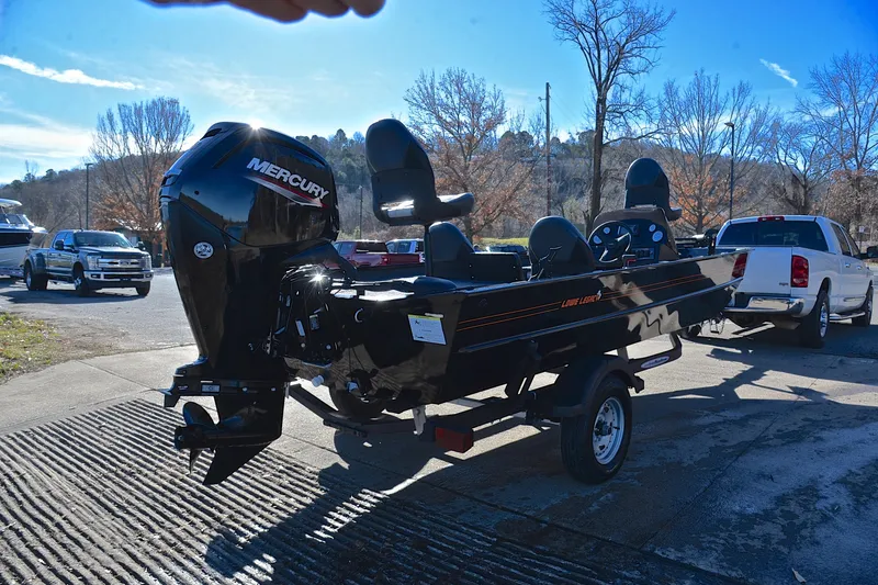 Slide: The Image of 2021 Lowe Legacy boat with Mercury engine on trailer, parked outdoors. - 12