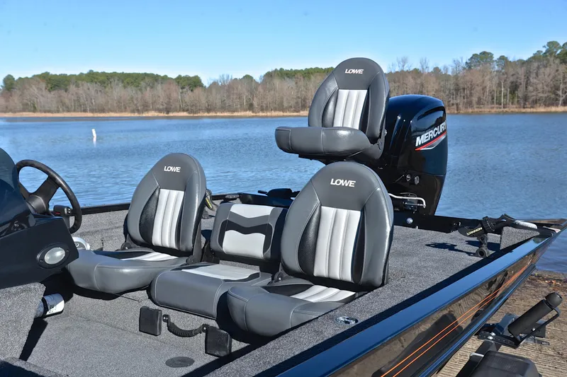 Slide: The Image of 2021 Lowe Legacy boat with comfortable seating, Mercury engine, on a serene lake backdrop. - 16