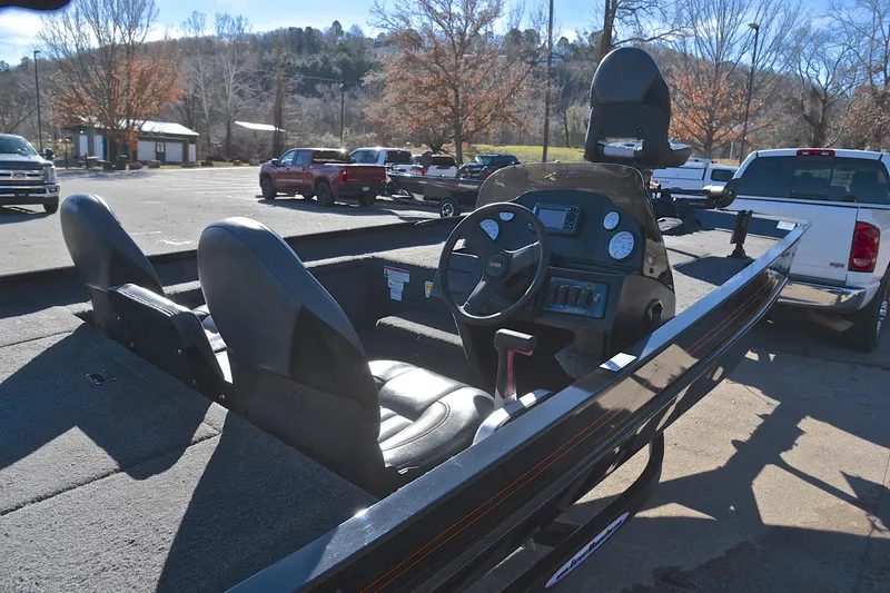 Slide: The Image of 2021 Lowe Legacy boat interior with steering console in a parking lot. - 17