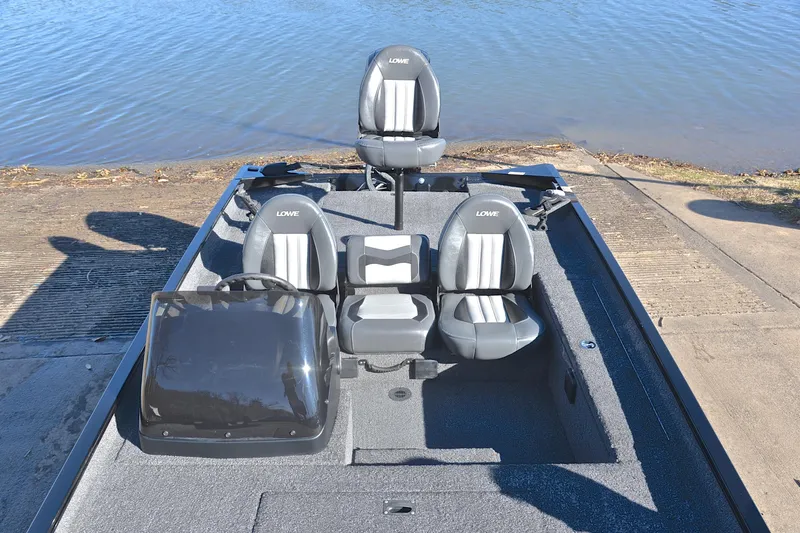 Slide: The Image of 2021 Lowe Legacy boat with three seats, docked by a calm lake. - 20
