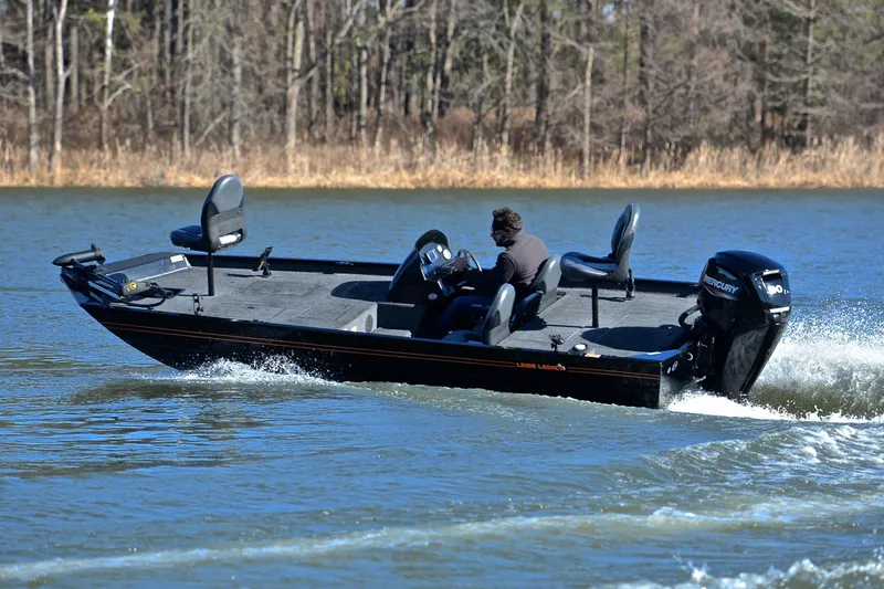 Slide: The Image of 2021 Lowe Legacy boat cruising on a lake with trees in the background. - 4