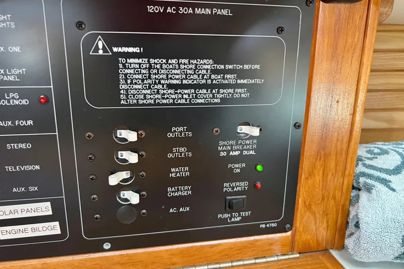 Slide: The Image of 1996 Catalina 400 electrical panel with switches and warning instructions. - 48