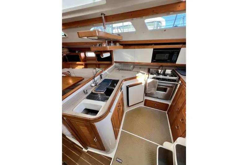 Slide: The Image of Interior of 1996 Catalina 400 yacht kitchen with modern appliances and wooden cabinetry. - 57
