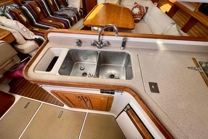 Slide: The Image of Interior of a 1996 Catalina 400 sailboat featuring a compact kitchen with dual sinks. - 59