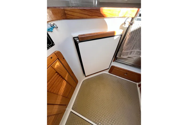 Slide: The Image of Interior of 1996 Catalina 400 sailboat with wooden cabinetry and compact fridge. - 62