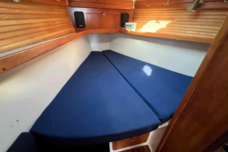 Slide: The Image of 1996 Catalina 400 sailboat cabin with blue cushions and wooden interior. - 65