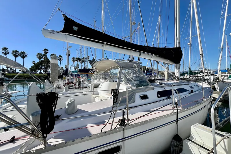 Slide: The Image of Sailboat Catalina 400, 1996 model, docked in a sunny marina with palm trees. - 7