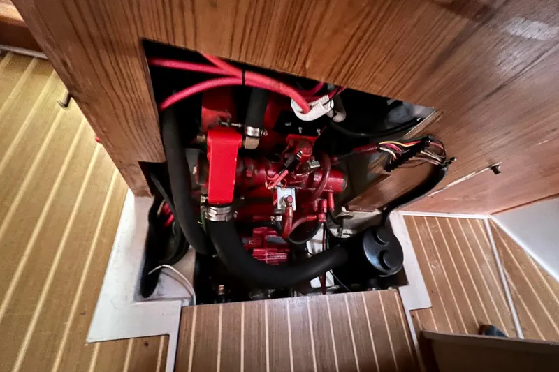 Slide: The Image of Engine compartment of a 1996 Catalina 400 sailboat, featuring red engine components. - 82