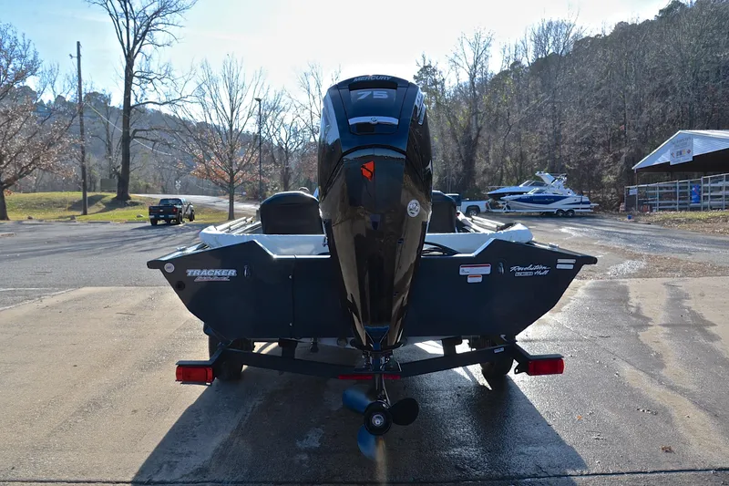 Slide: The Image of 2022 Bass Tracker 175 TF boat on trailer, parked near a scenic lakeside area. - 13
