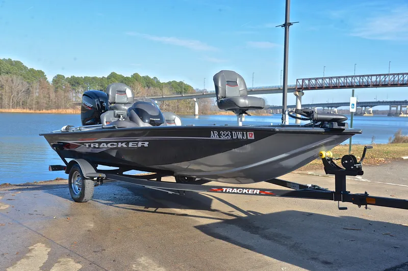 Slide: The Image of 2022 Bass Tracker 175 TF boat on trailer by a lake with bridge in background. - 16