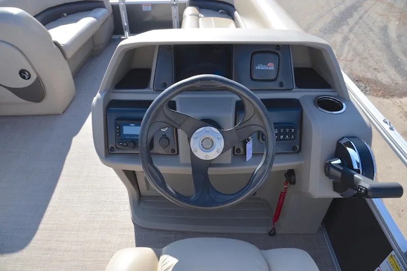 Slide: The Image of 2025 Sun Tracker Party Barge 18 DLX steering console with controls and seating. - 24