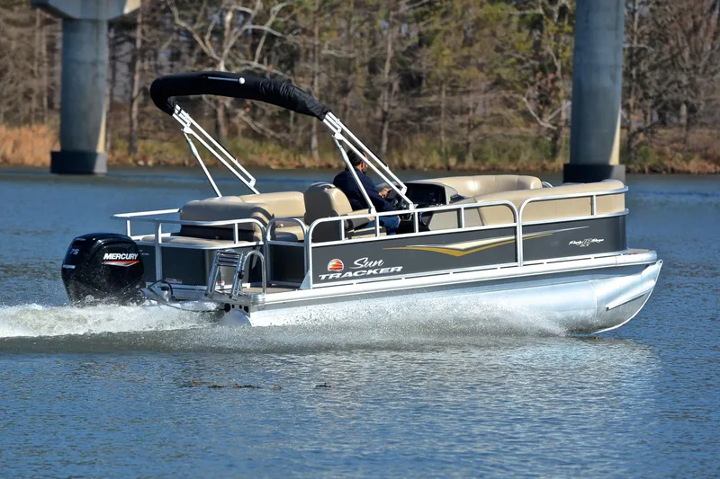 Slide: The Image of 2025 Sun Tracker Party Barge 18 DLX pontoon boat cruising on a lake. - 5