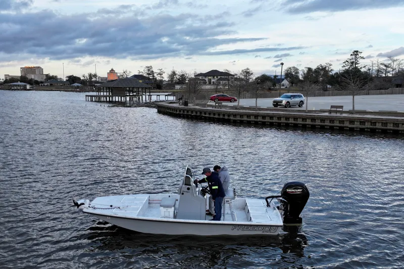 Slide: The Image of Freedom Boats 18' Patriot 2025 on a calm waterway. - 9