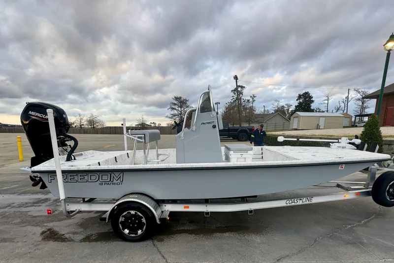 Slide: The Image of 2025 Freedom Boats 18' Patriot on trailer, cloudy sky. - 14