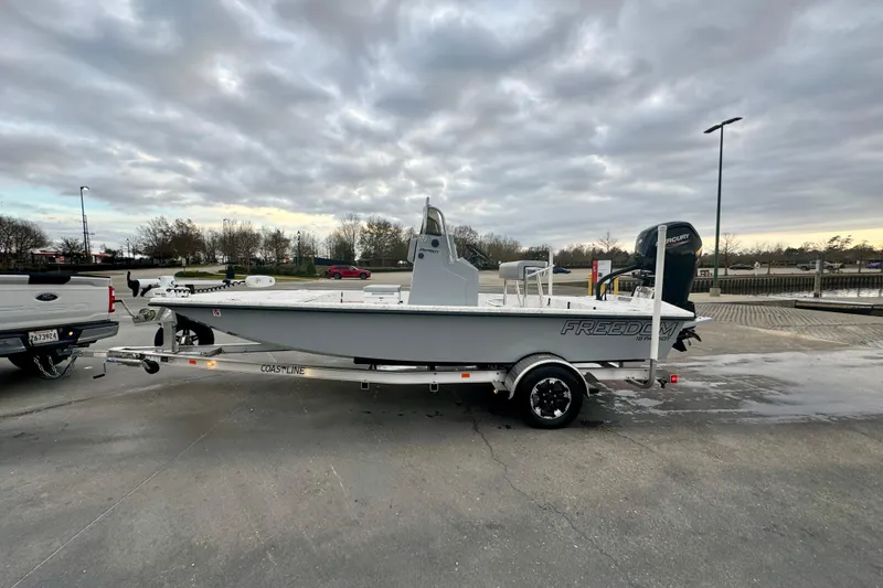 Slide: The Image of 2025 Freedom Boats 18' Patriot on trailer under cloudy sky. - 20