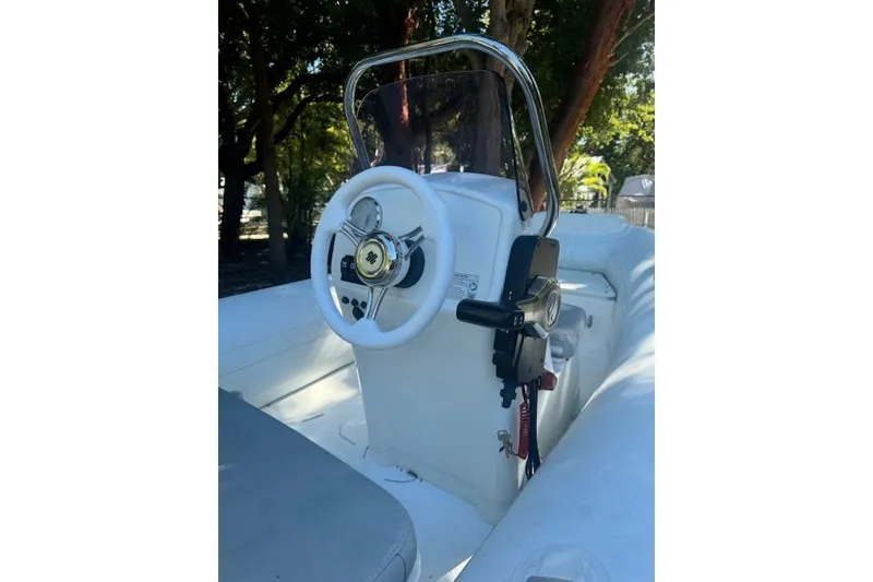 Slide: The Image of 2022 Grand Marine S370 boat console with steering wheel and controls, set against a wooded backdrop. - 4