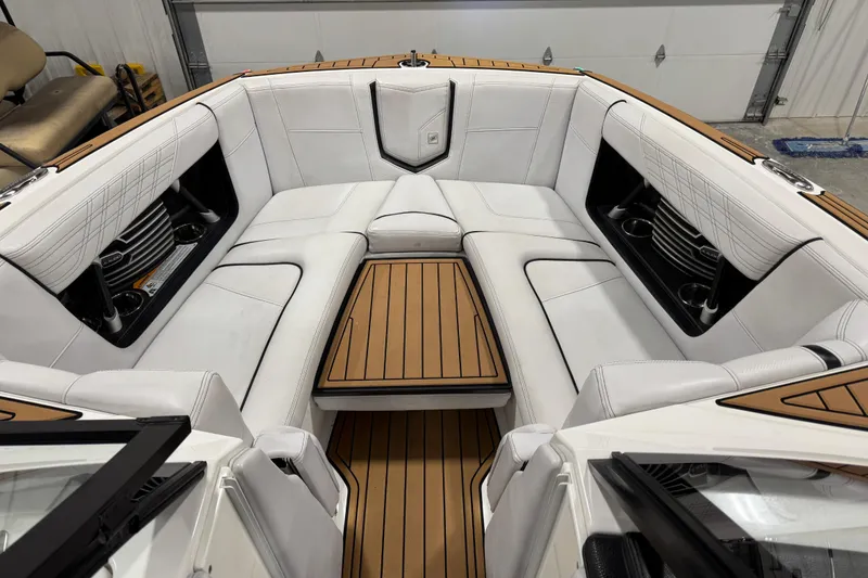 Slide: The Image of 2019 Nautique Super Air Nautique G23 boat interior with white seating and wood accents. - 11