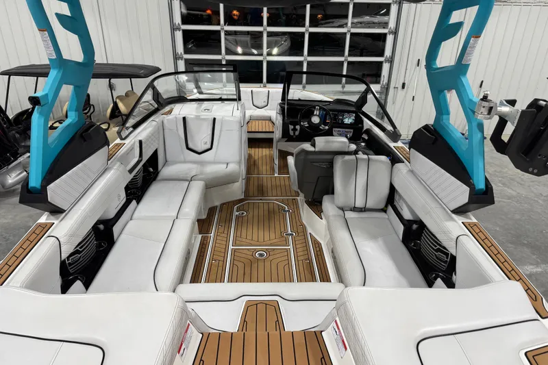 Slide: The Image of 2019 Nautique Super Air Nautique G23 interior with white seating and teak flooring. - 7