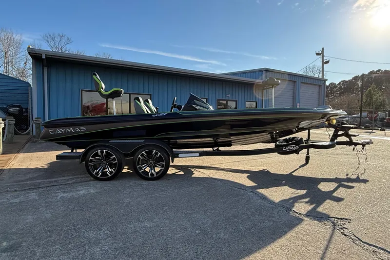 Slide: The Image of 2021 Caymas CX 21 boat on trailer, parked outside blue building under clear sky. - 4