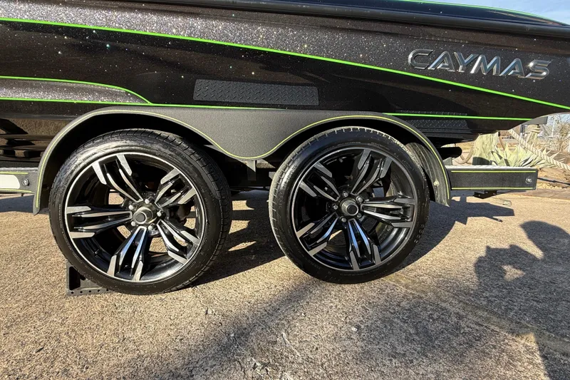 Slide: The Image of 2021 Caymas CX 21 boat trailer with sleek black alloy wheels and green accents. - 6