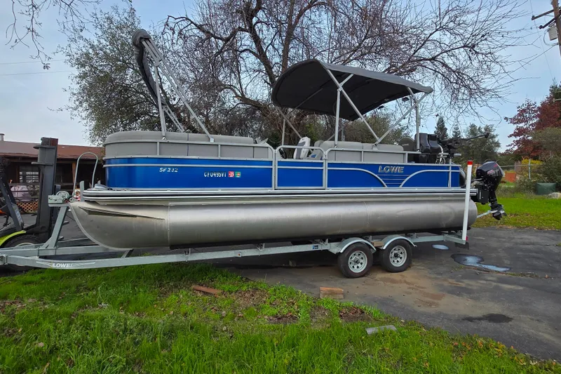 The Image of 2020 Lowe SF 232 Sport Fish pontoon boat on trailer, parked outdoors. - 1