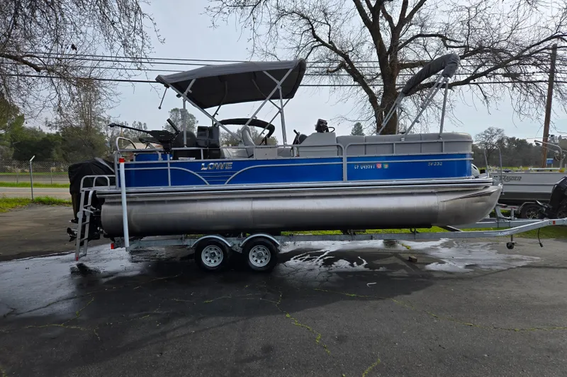 Slide: The Image of 2020 Lowe SF 232 Sport Fish pontoon boat on trailer, parked outdoors. - 3