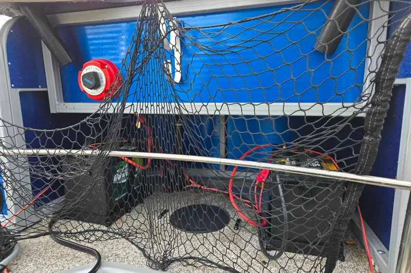 Slide: The Image of 2020 Lowe SF 232 Sport Fish boat interior with fishing net and battery setup. - 9