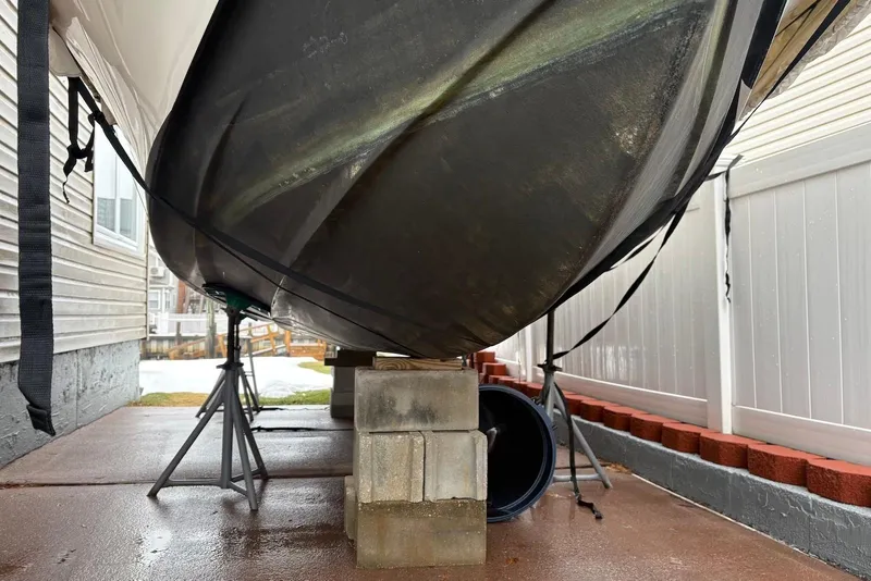 Slide: The Image of Dusky 227 boat from 2025, supported on blocks and stands, under a shelter. - 11