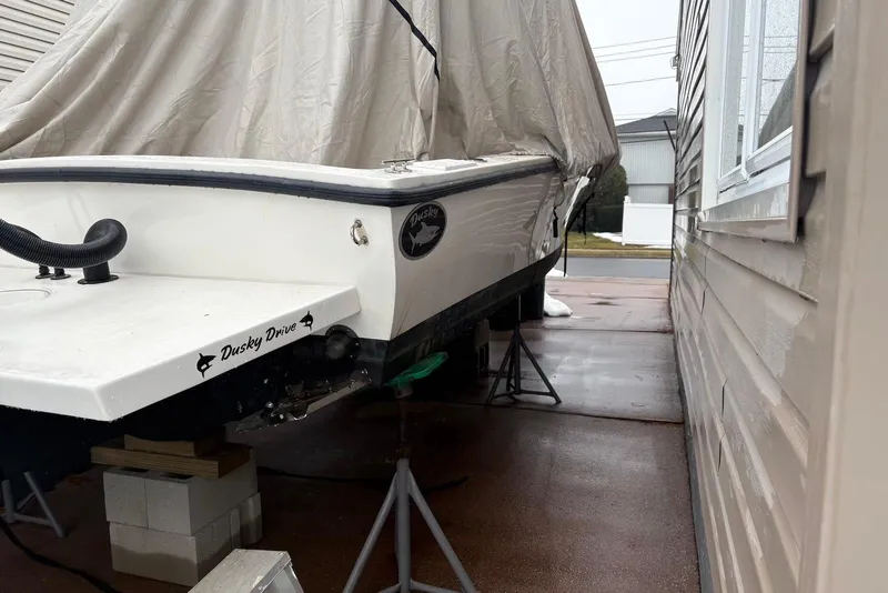 Slide: The Image of Covered 2025 Dusky 227 boat on stands beside a house. - 13