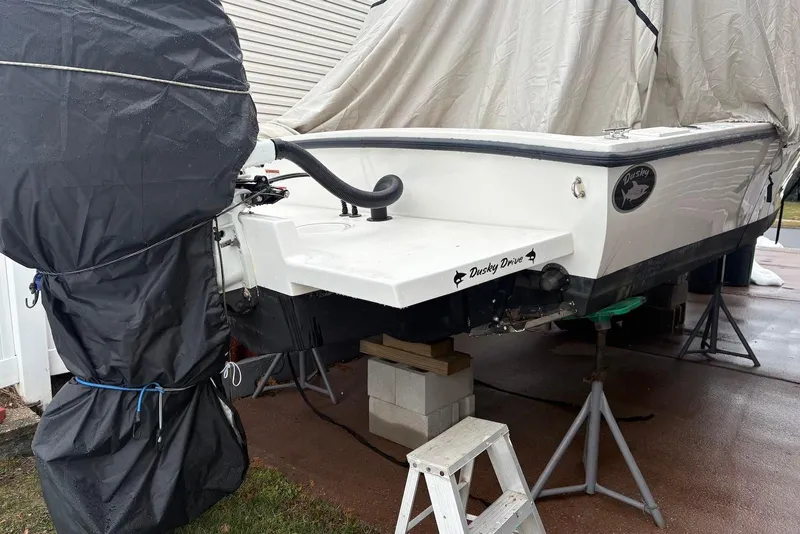 Slide: The Image of 2025 Dusky 227 boat with covered outboard motor on stands, rear view. - 15