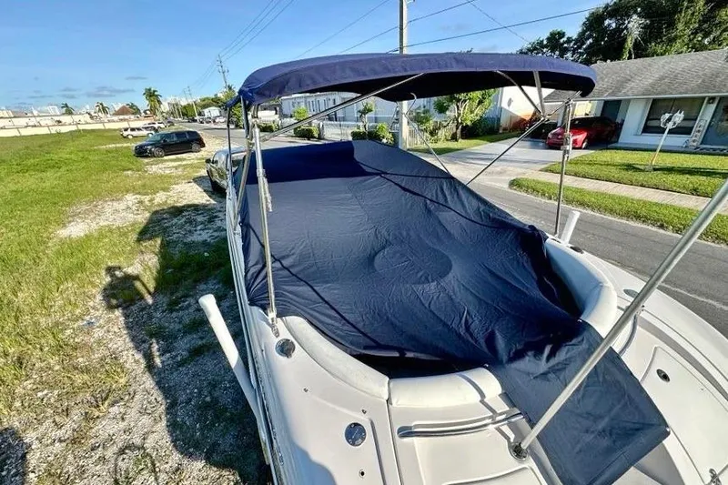 Slide: The Image of 2005 Four Winns 264 Funship boat with blue cover and canopy, parked on grass. - 13