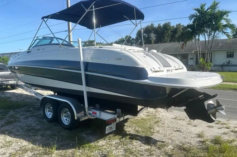 Slide: The Image of 2005 Four Winns 264 Funship boat on trailer, parked outdoors under blue sky. - 3