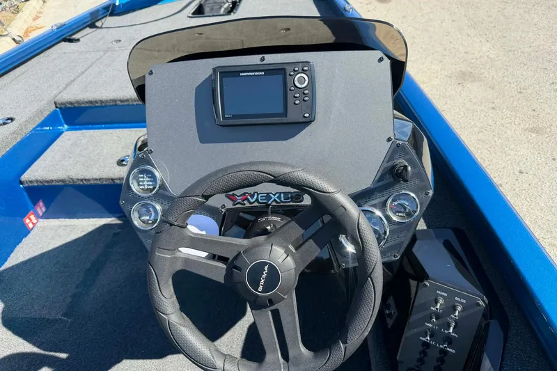 Slide: The Image of 2026 Vexus Defender 189 boat dashboard with steering wheel and navigation system. - 10