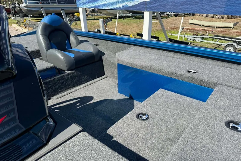 Slide: The Image of 2026 Vexus Defender 189 boat interior with gray and blue seating and carpeted flooring. - 7