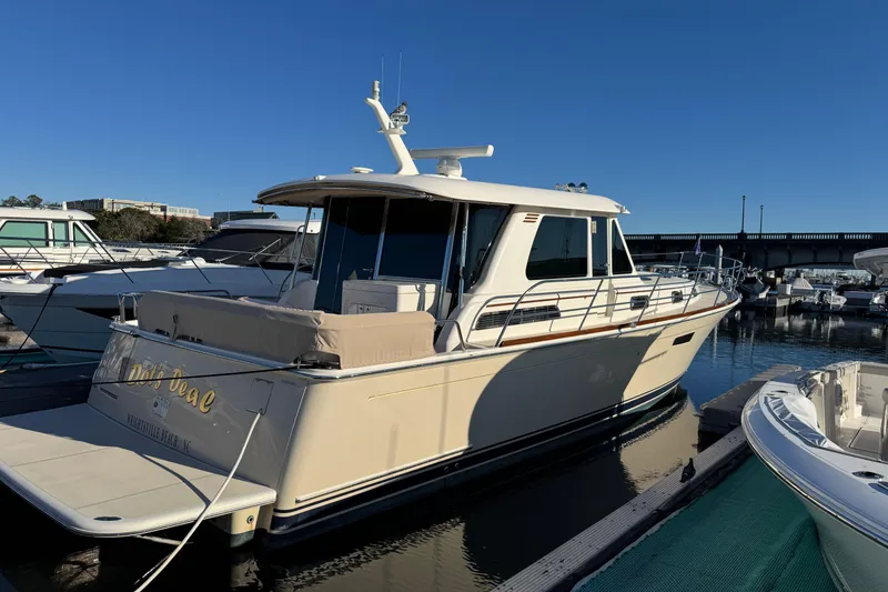 The Image of 2023 Sabre 48 Salon Express yacht docked at marina under clear blue sky. - 0